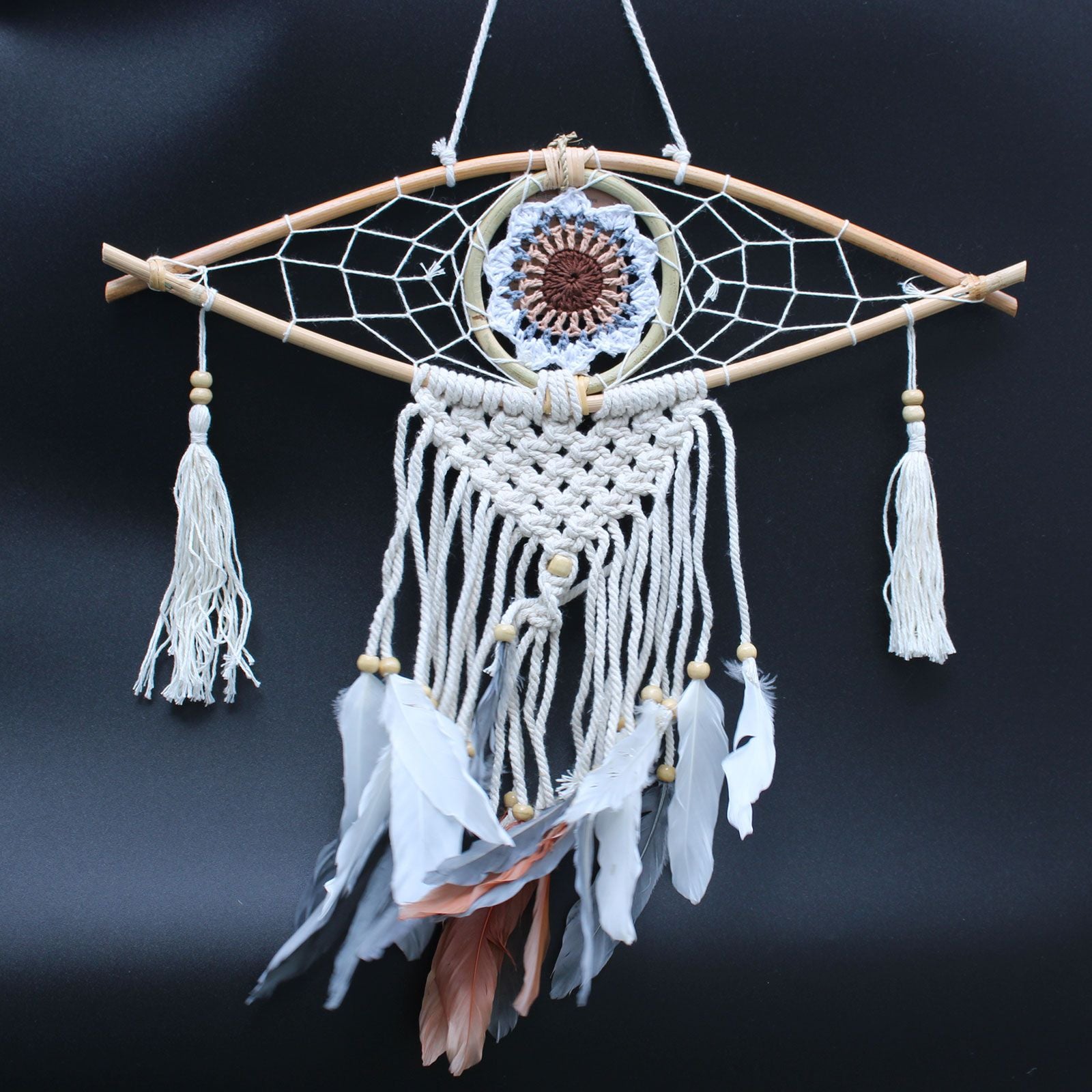 Dreamcatcher with feathers and beads on a dark background