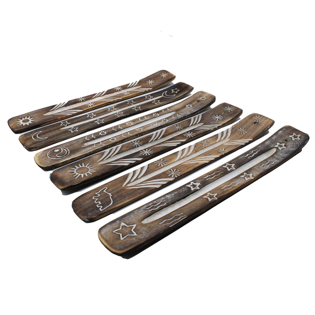 Set of wooden incense sticks with engraved designs on a white background