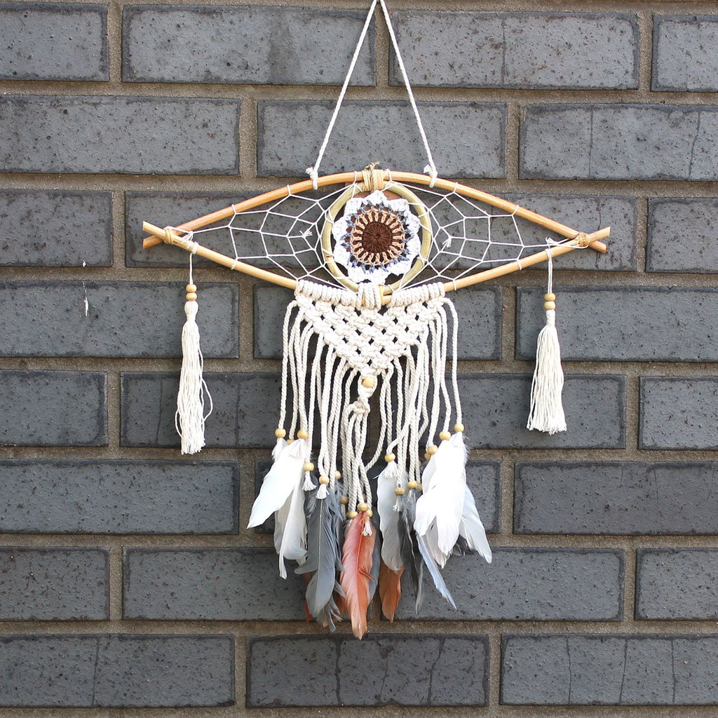 Dreamcatcher with feathers hanging on a brick wall