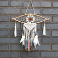 Dreamcatcher with feathers hanging on a brick wall