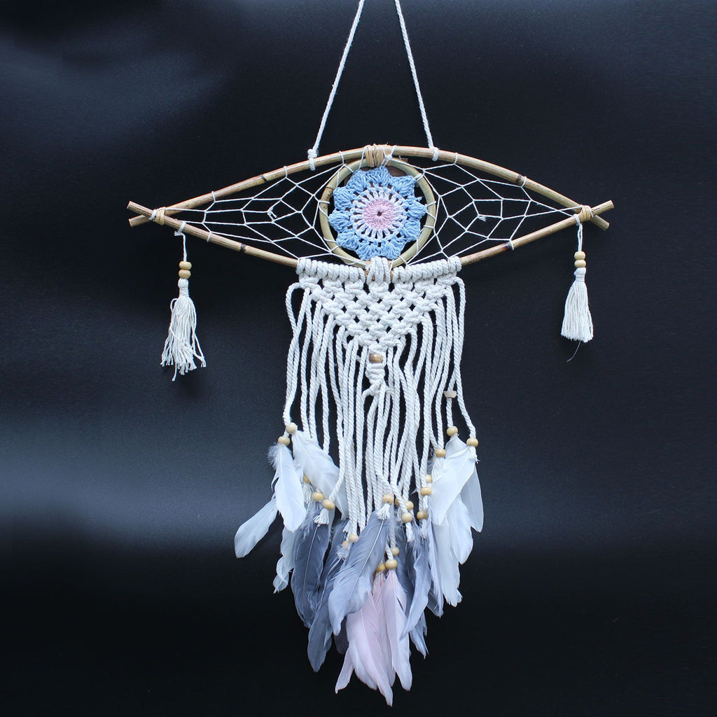 Decorative dreamcatcher with feathers and beads on a dark background