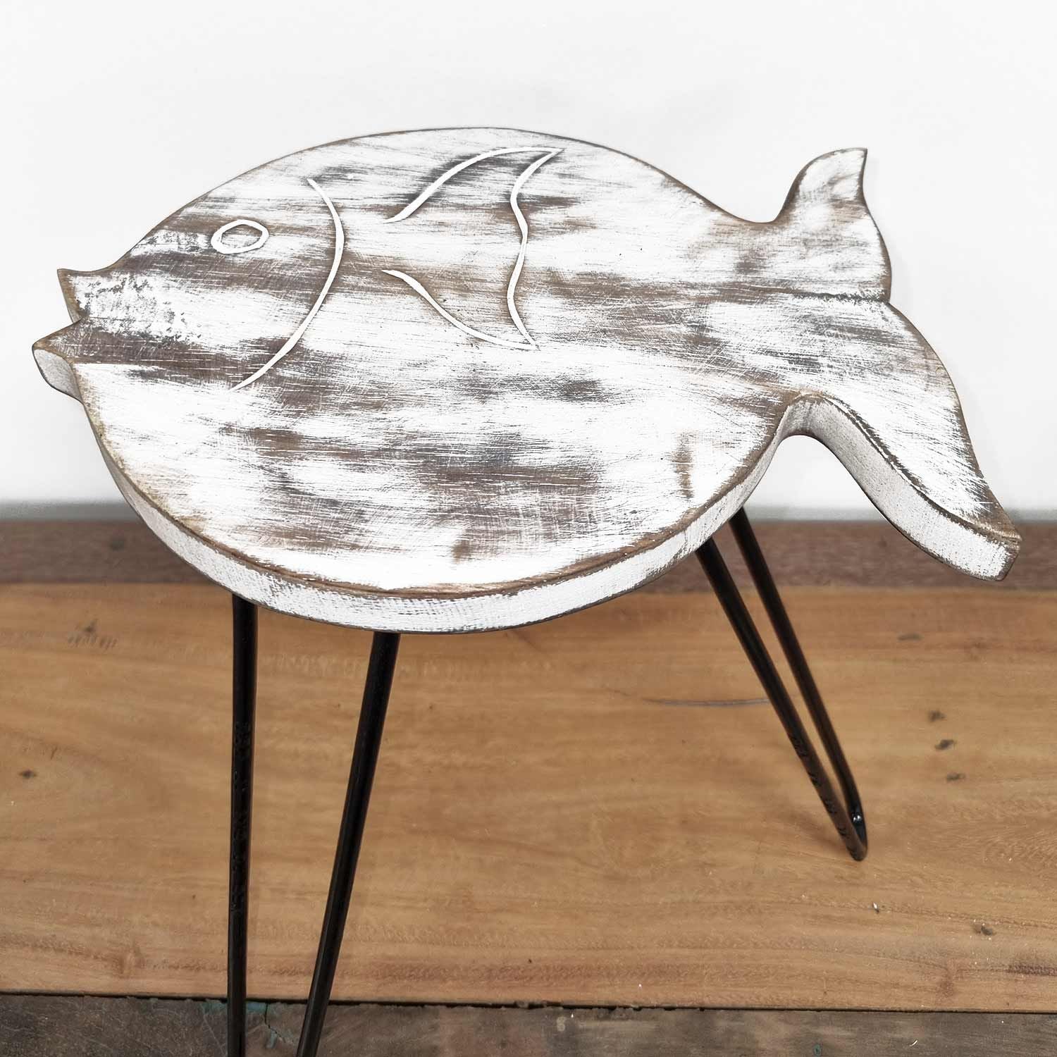 Fish-shaped table with white distressed finish on a wooden surface