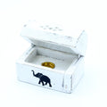 White wooden box with a black elephant design and gold interior on a white background