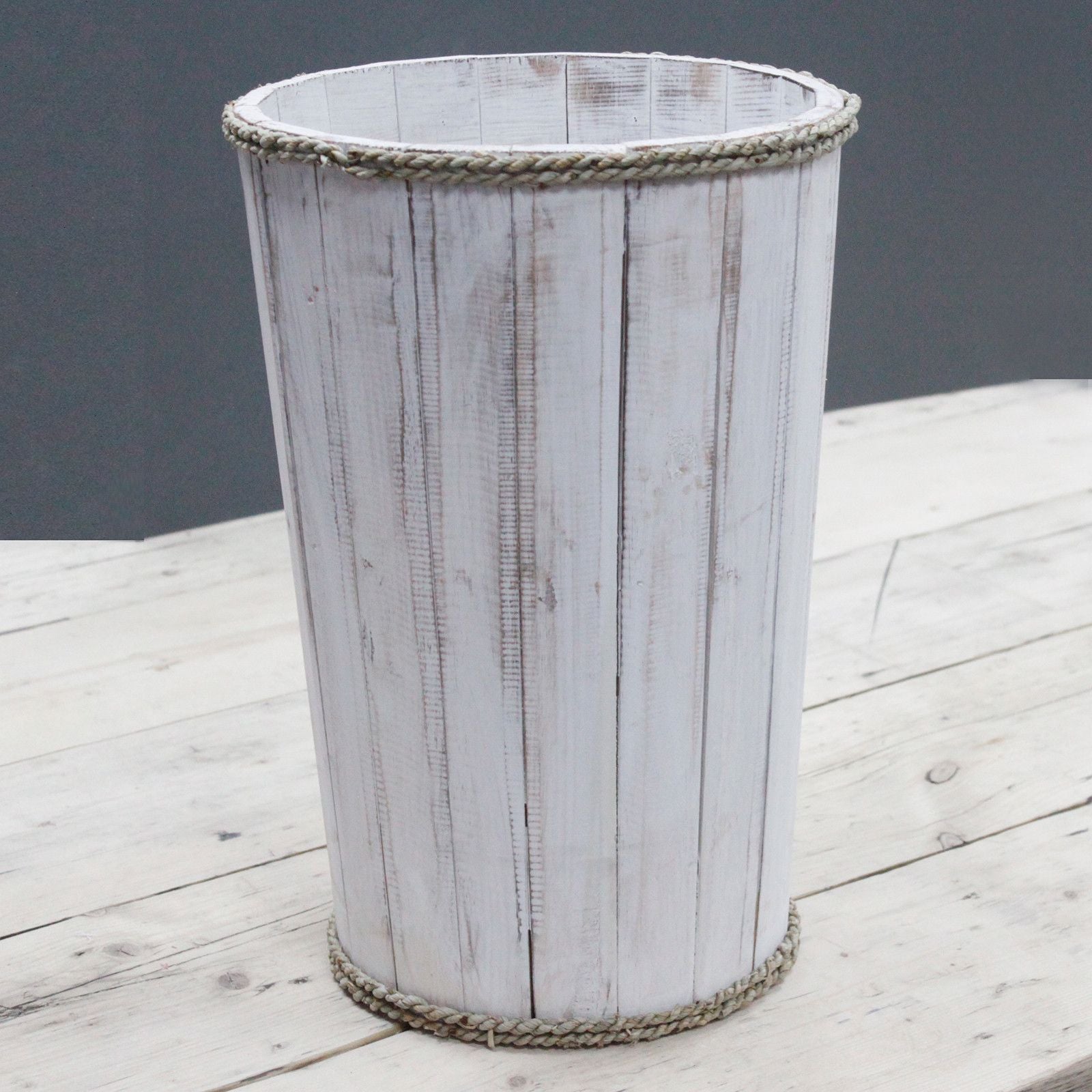 Decorative trash bin with a rustic design on a wooden surface