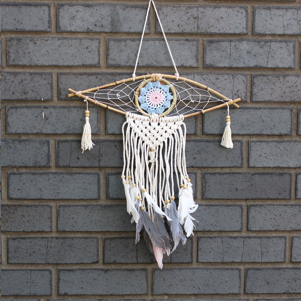 Dreamcatcher with feathers hanging on a brick wall