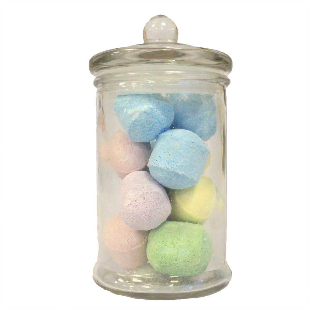 Glass jar filled with pastel-colored bath bombs on a white background