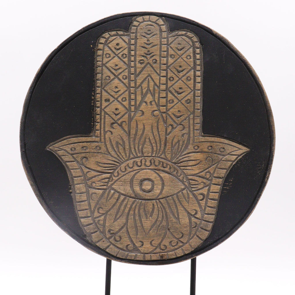 Decorative plate with Hamsa hand design on a black background