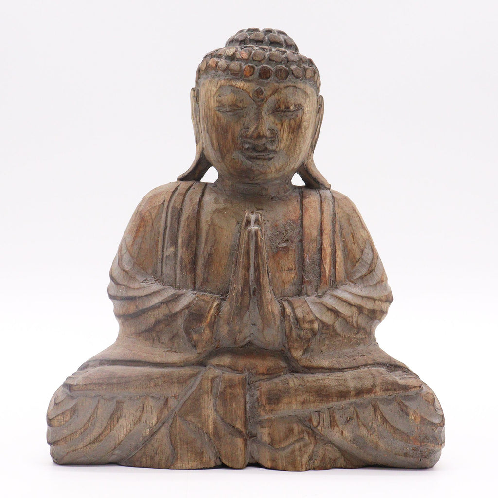 Wooden Buddha statue with hands in prayer position on a white background
