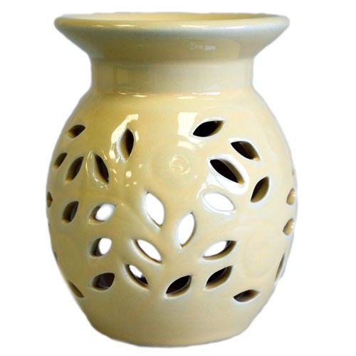 Beige ceramic oil burner with a white base on a white background