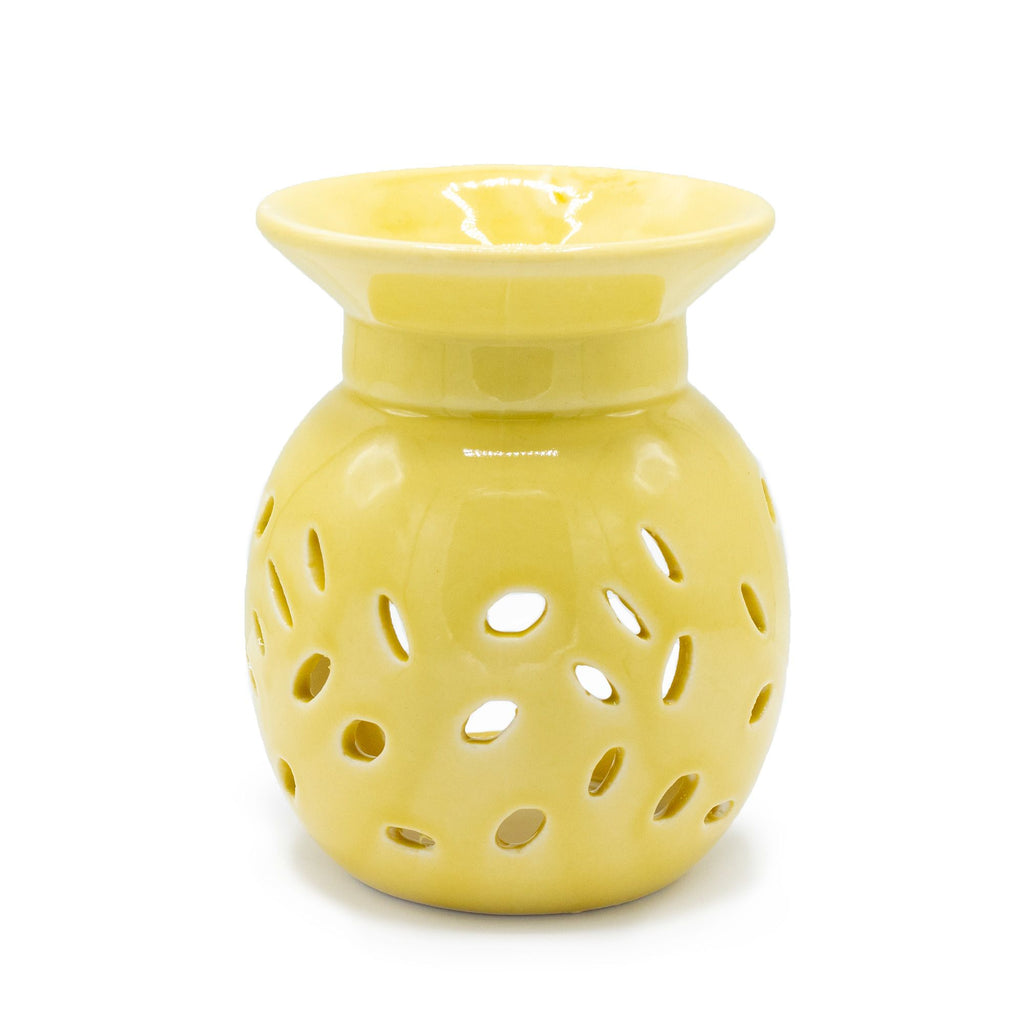 Yellow ceramic oil burner with perforated design on a white background