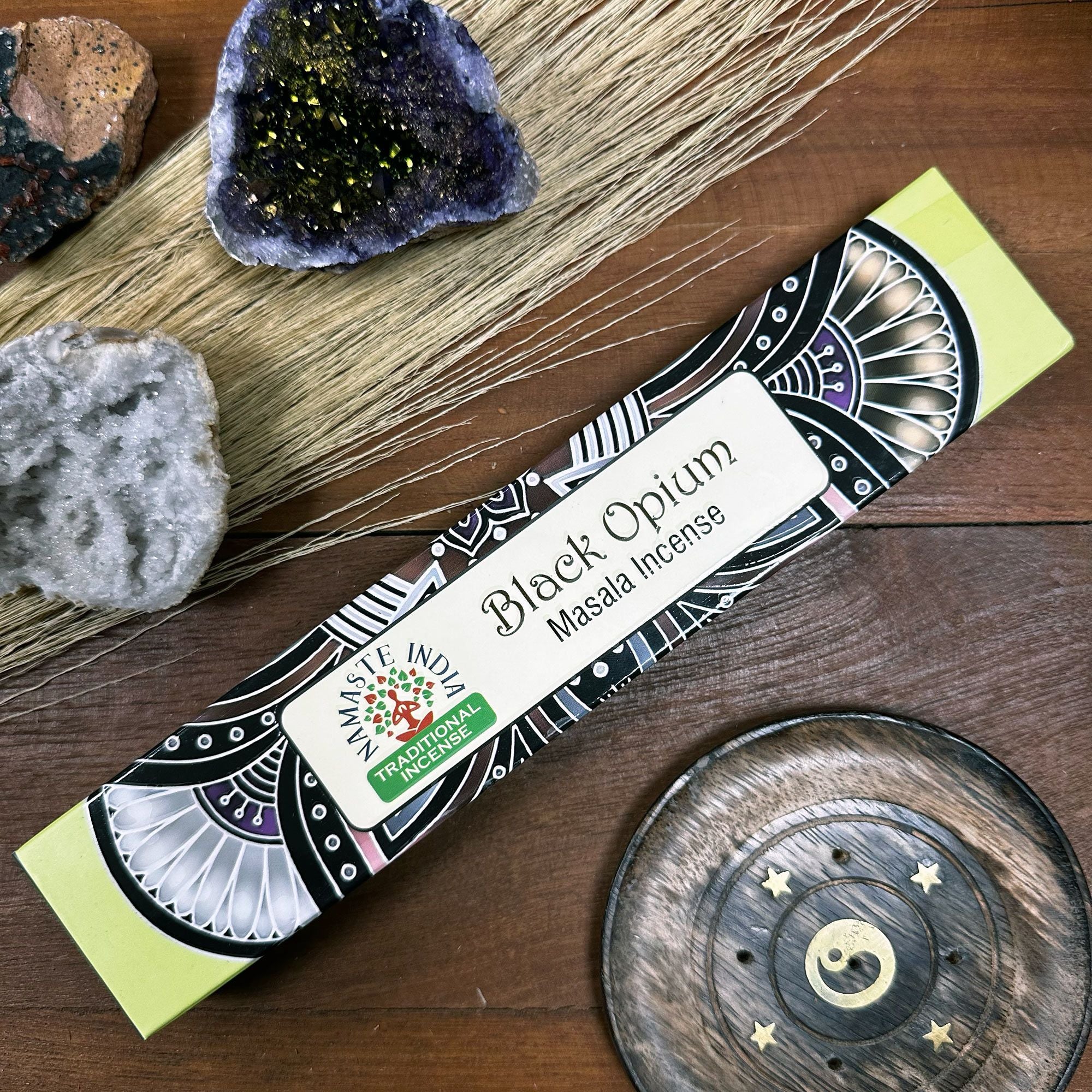 Box of Black Opium Masala Incense with decorative elements on a wooden surface