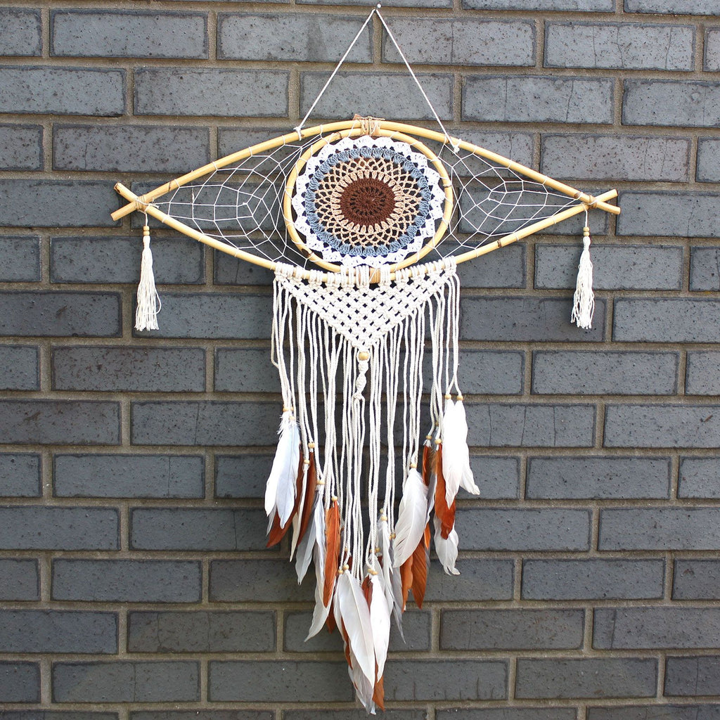 Dreamcatcher with feathers hanging on a brick wall