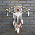 Dreamcatcher with feathers hanging on a brick wall