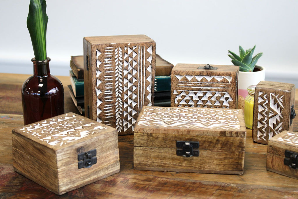 Set of wooden boxes with geometric patterns on a wooden surface.