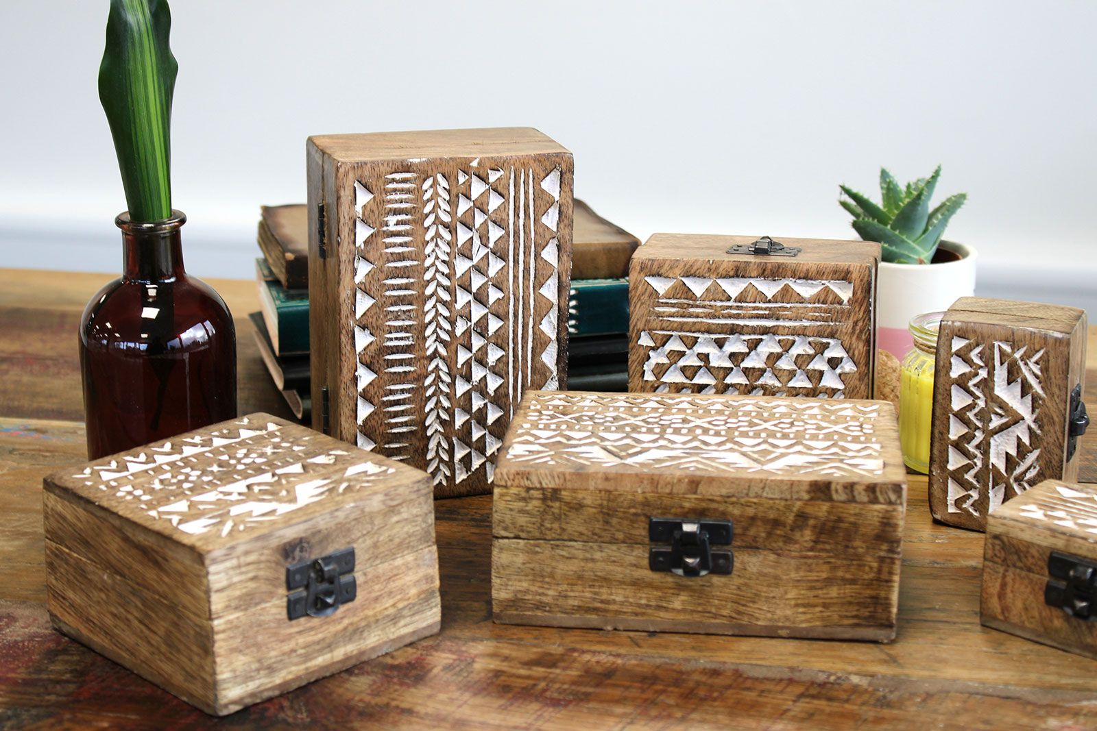 Set of wooden boxes with geometric patterns on a wooden surface.