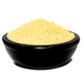 Black bowl filled with yellow granules on a white background