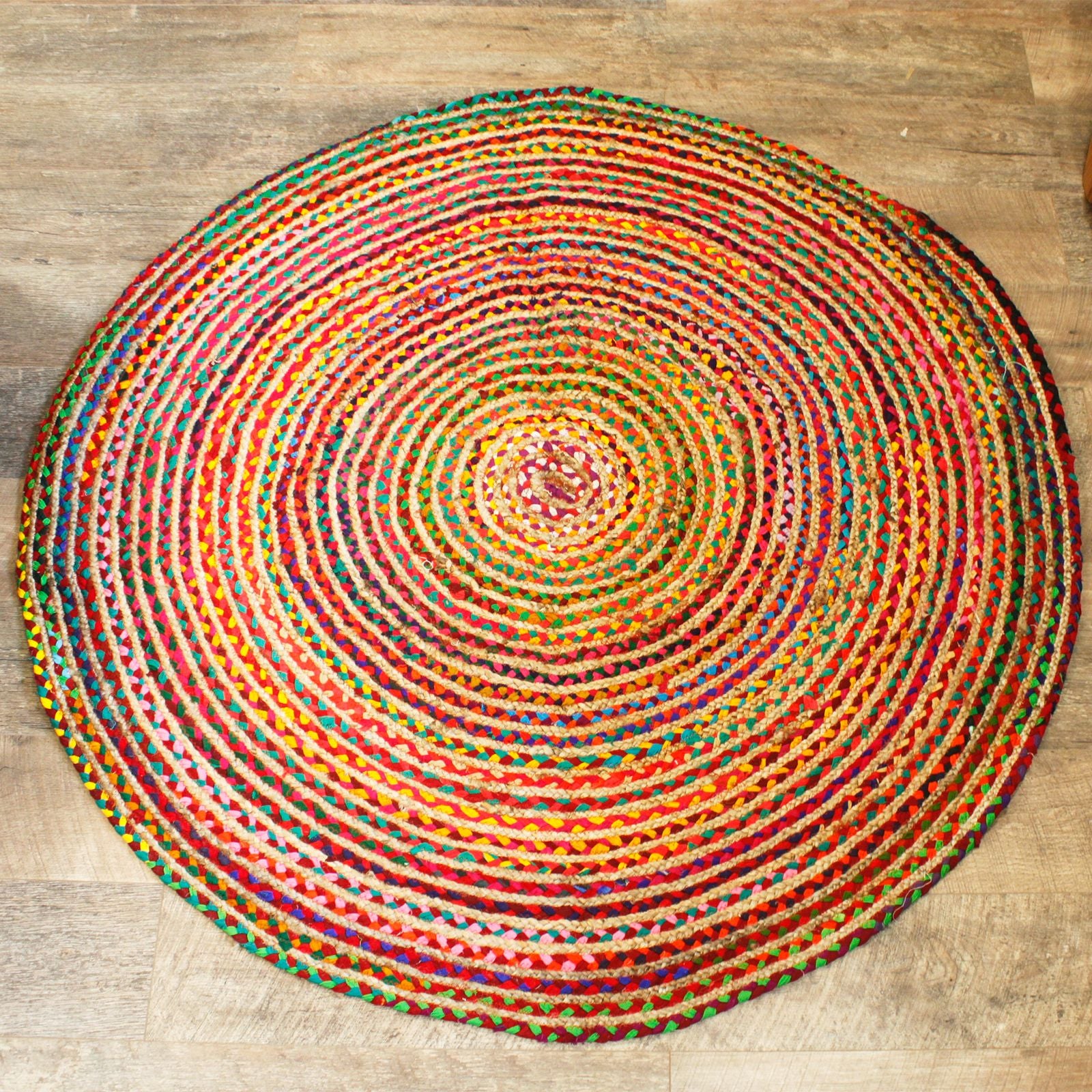 Round multicolored braided rug on a wooden floor