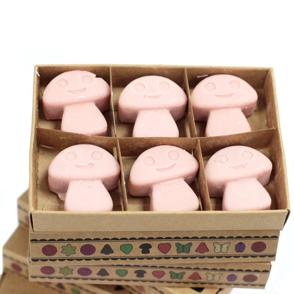 Box of pink mushroom-shaped soap bars with a smiley face design on a white background
