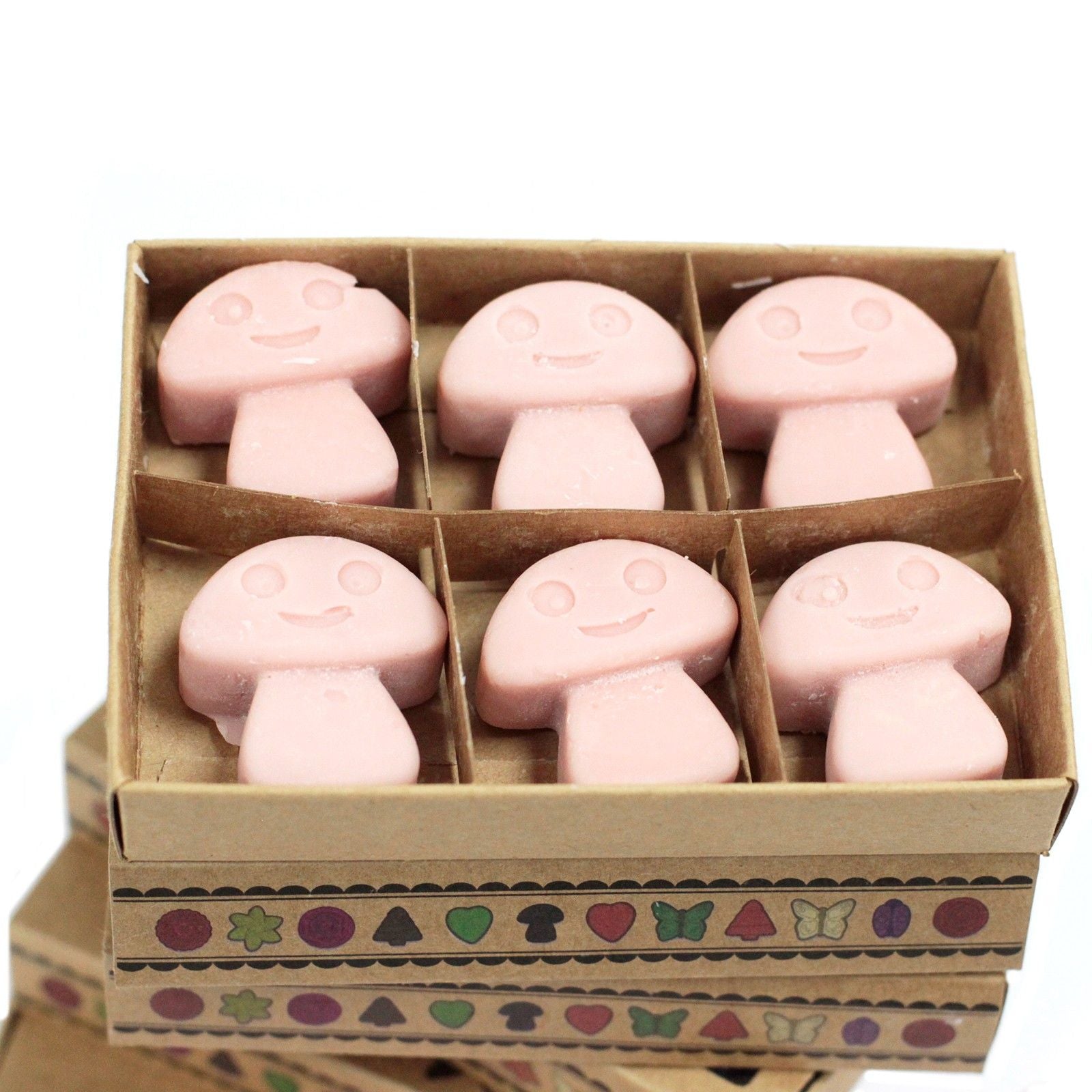 Box of pink mushroom-shaped soap bars with a smiley face design on a white background