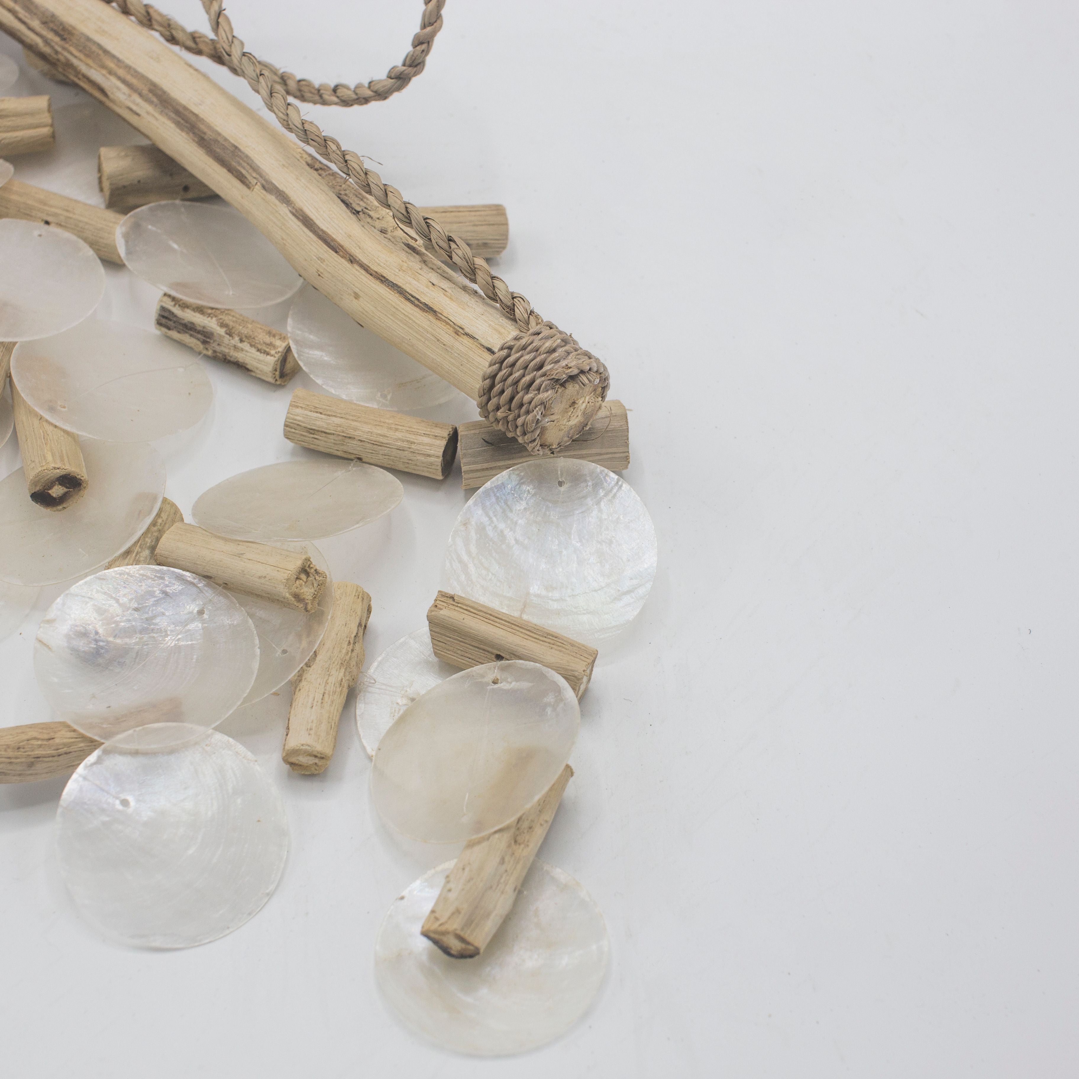 Necklace with clear beads and wooden sticks on a light background