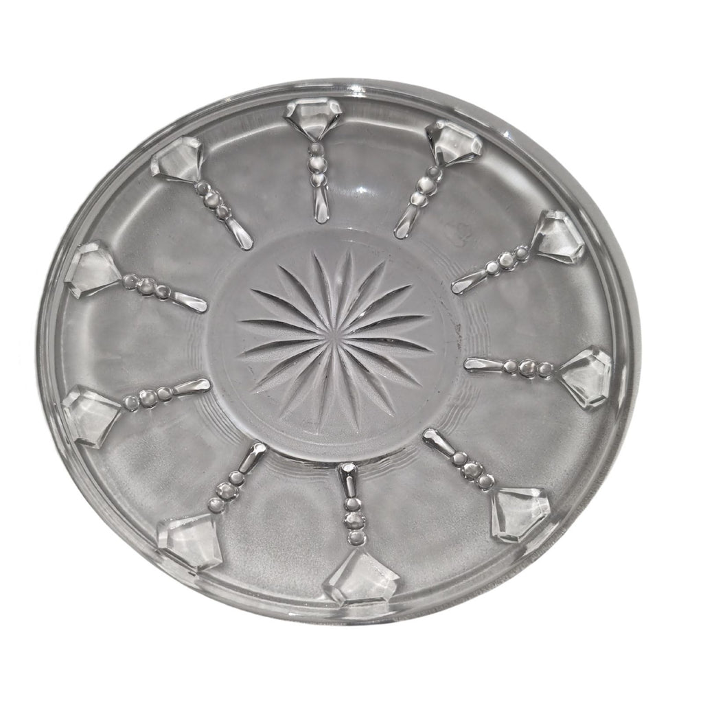 Decorative round metal tray with starburst design and geometric patterns on a white background