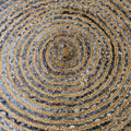 Close-up of a woven circular mat with concentric circles in brown and gray.