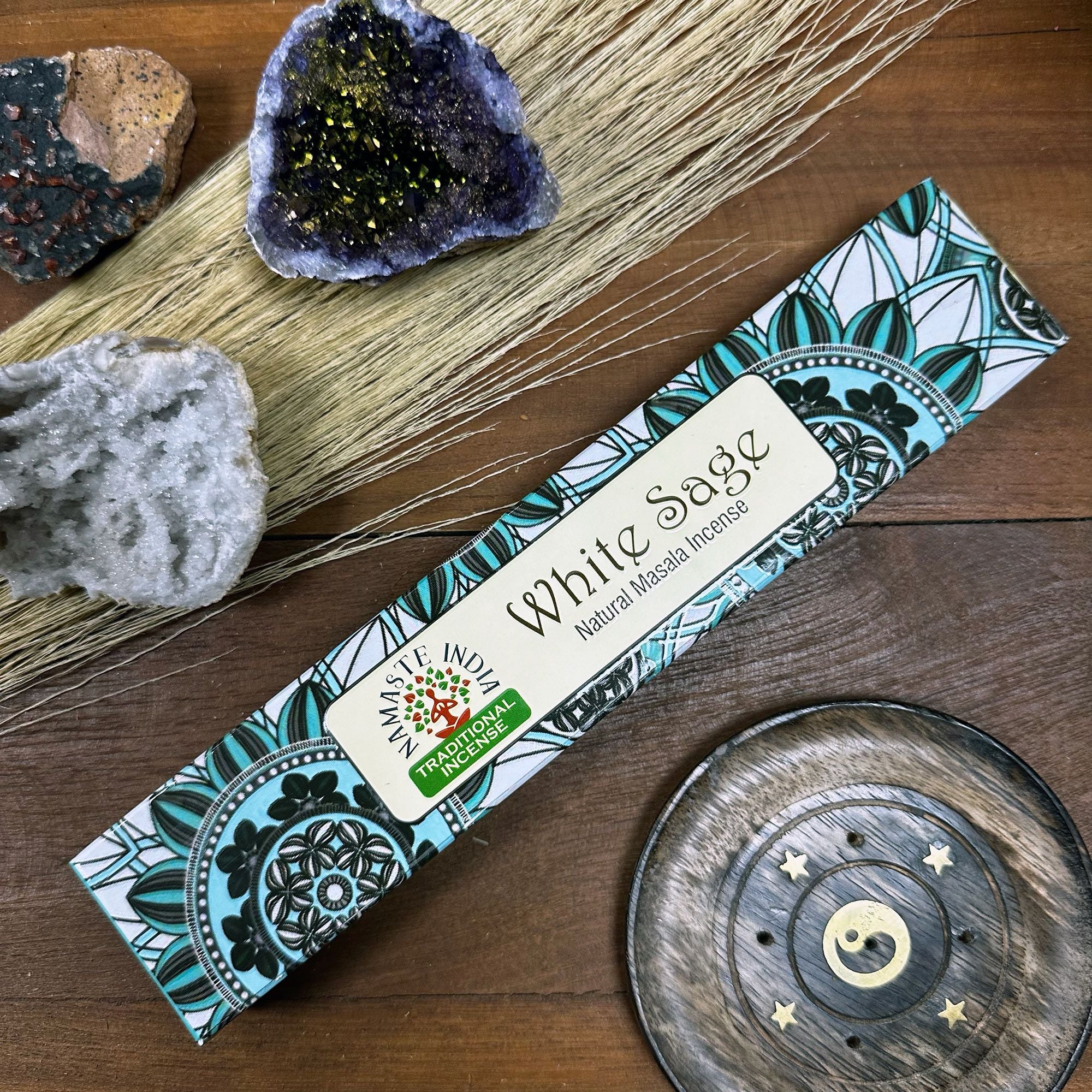 Box of White Sage incense with decorative elements on a wooden surface