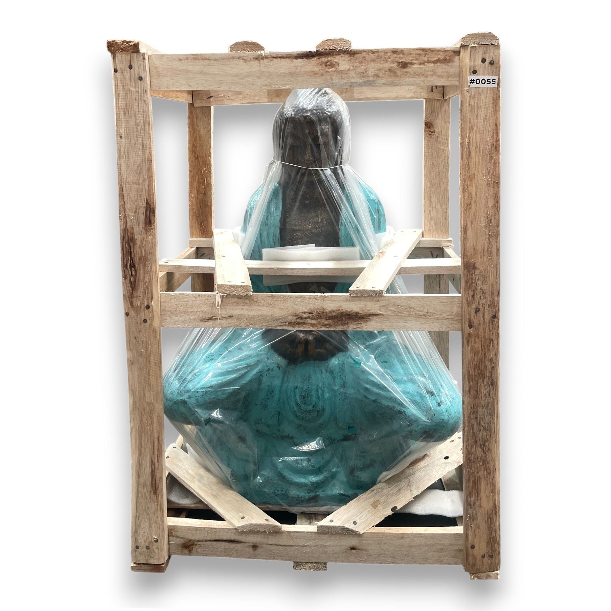 Teal Buddha statue wrapped in plastic on a wooden pallet