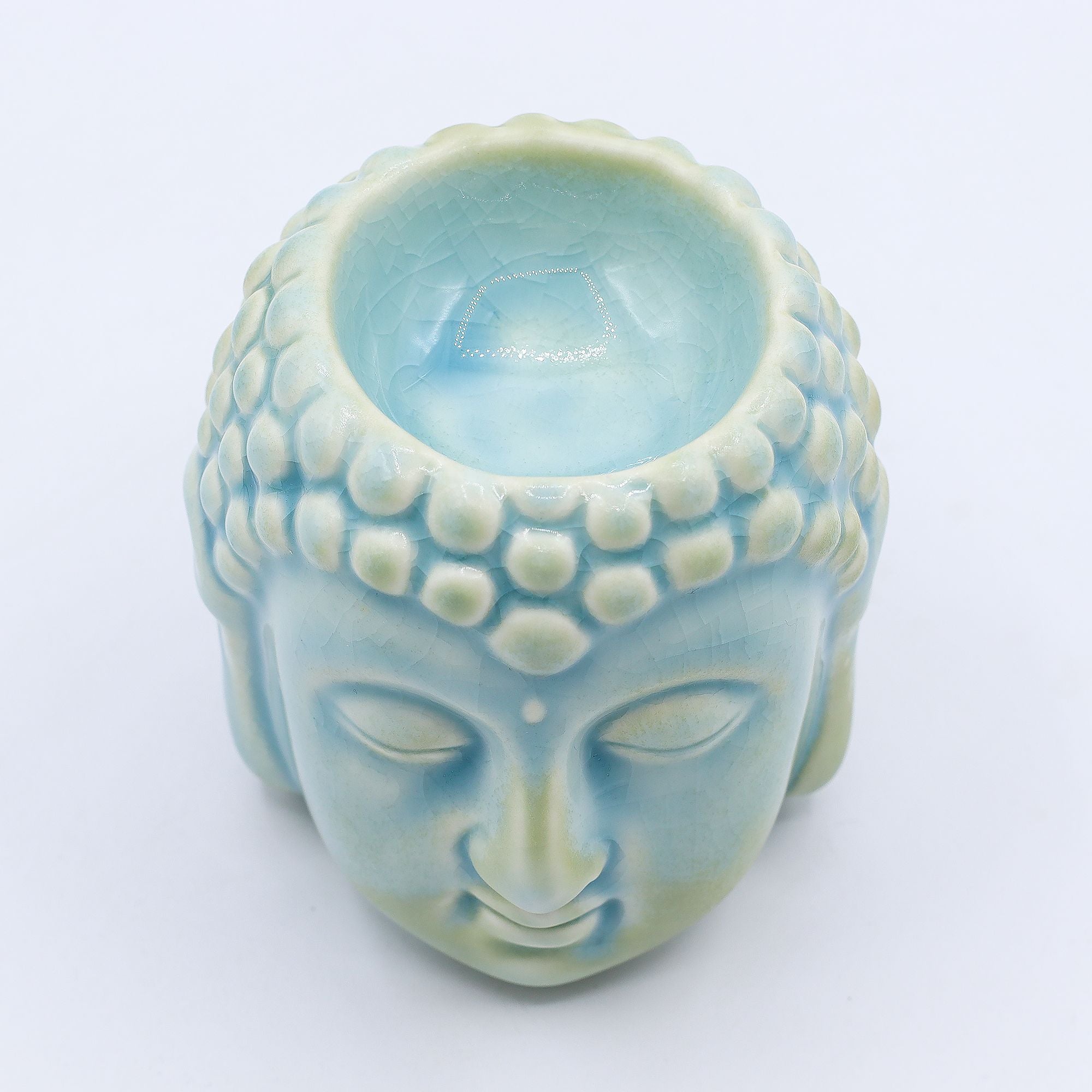 Ceramic Buddha head with a light blue interior on a white background