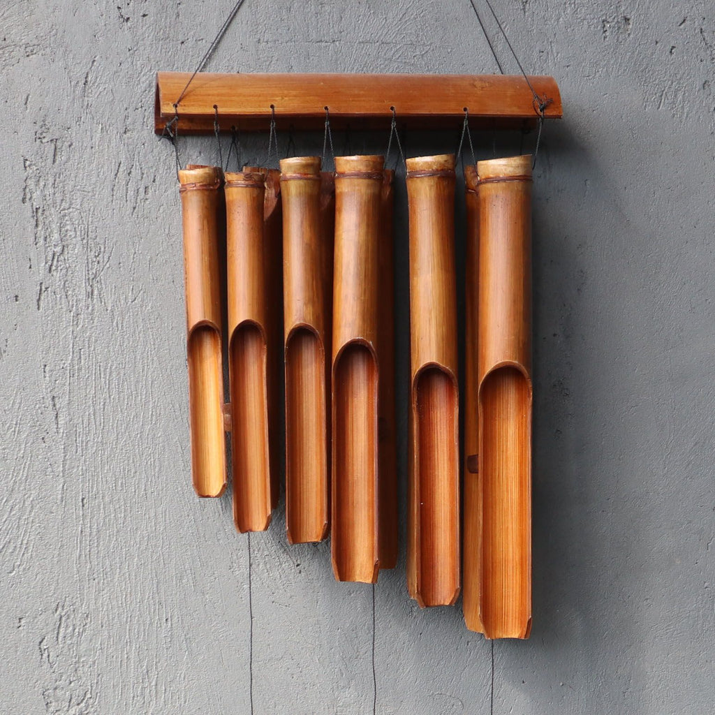 Bamboo wind chime hanging on a gray wall