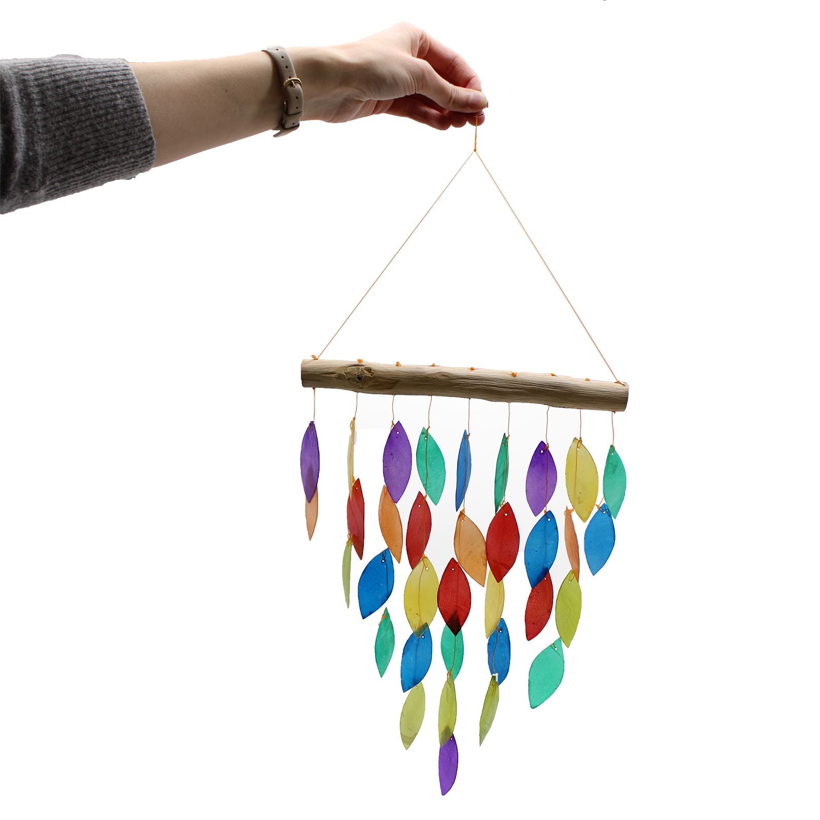 Colorful wind chime with wooden stick held by a hand on a white background
