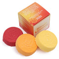 Three round bath bombs in red, orange, and yellow with a box labeled 'Strength & Creativity' on a white background.