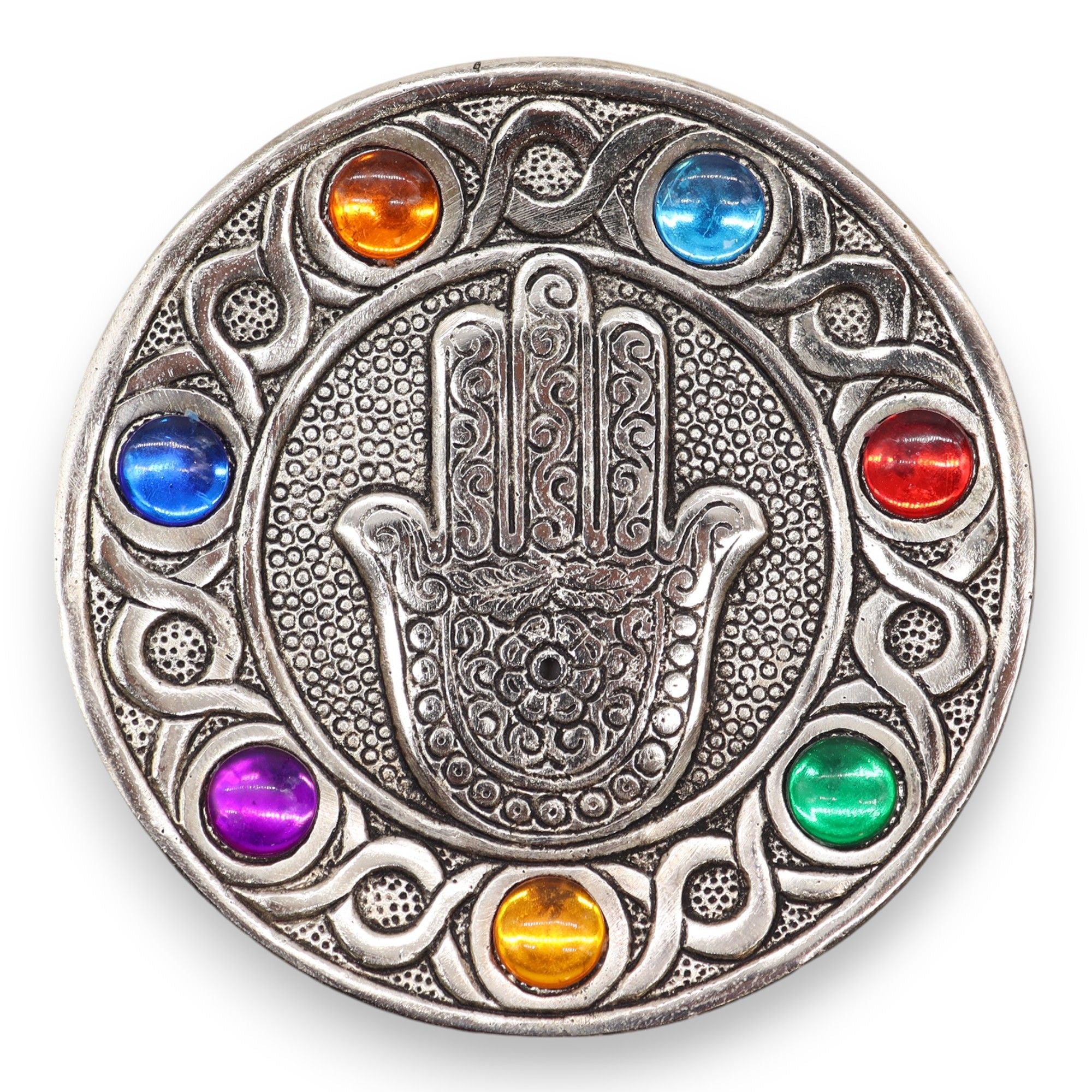 Circular metallic object with Hamsa hand design and colorful stones on a white background