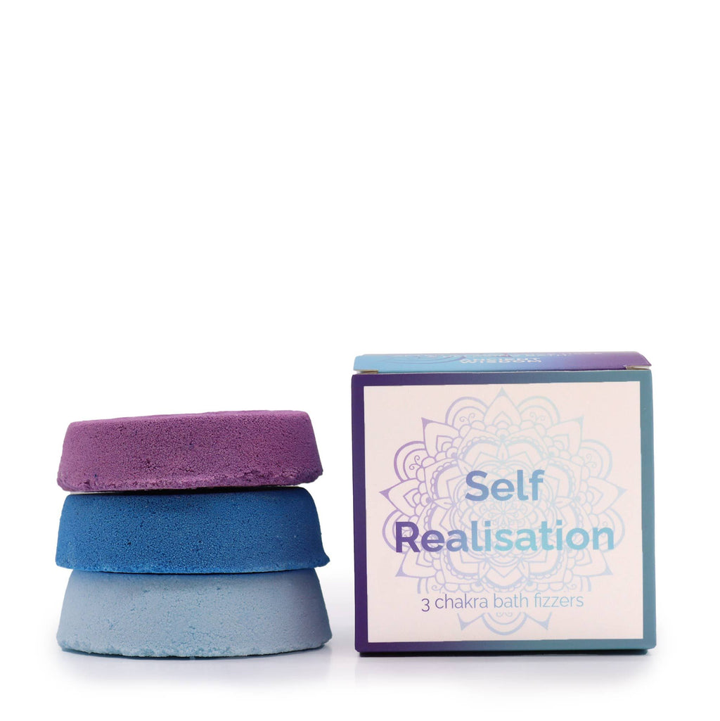 Three chakra bath fizzers stacked with their packaging labeled 'Self Realisation' on a white background.