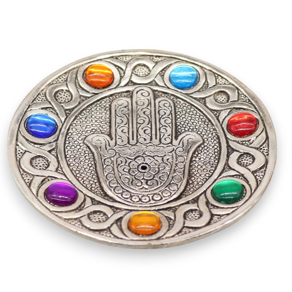 Decorative plate with Hamsa hand design and colorful stones on a white background