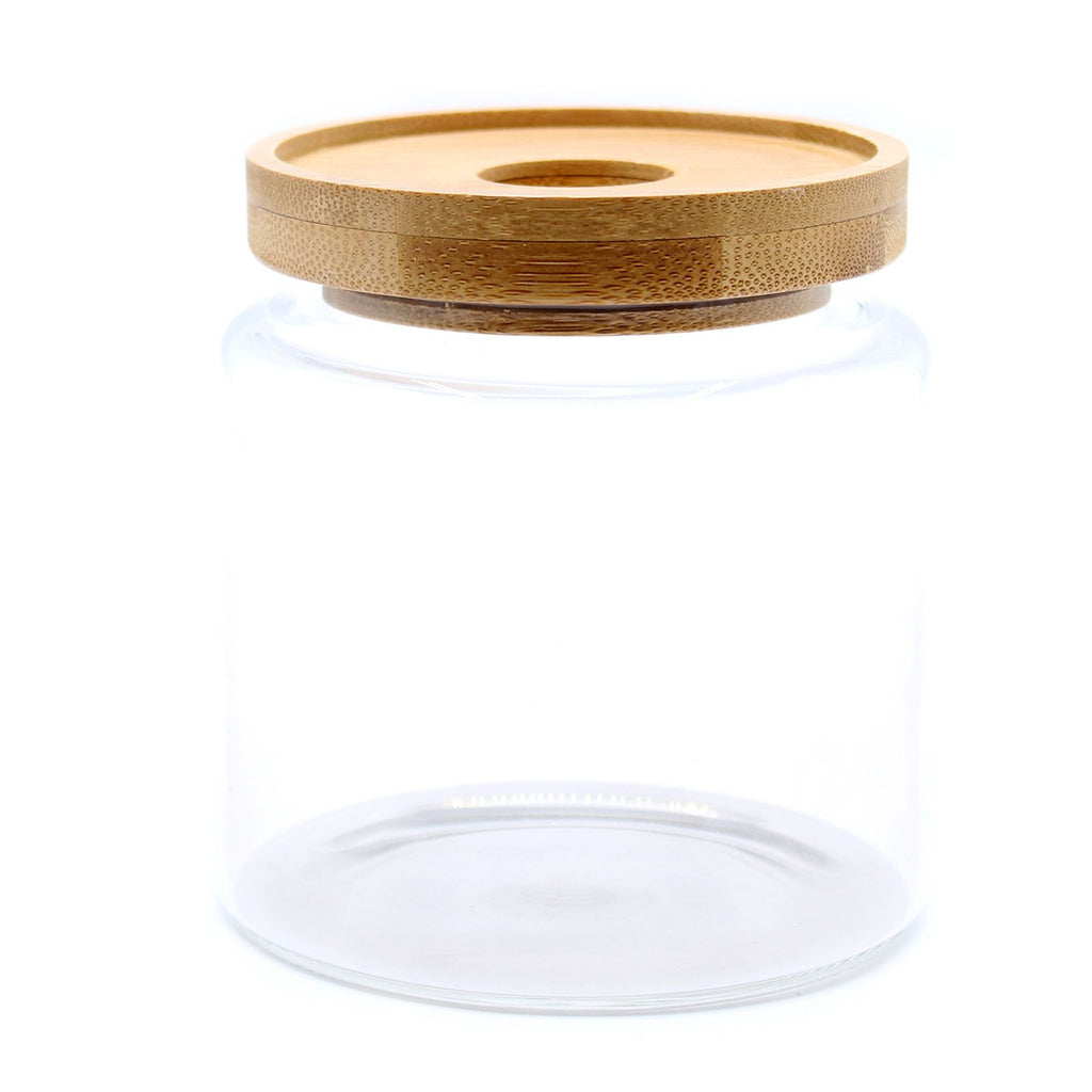 Clear glass jar with a wooden lid on a white background
